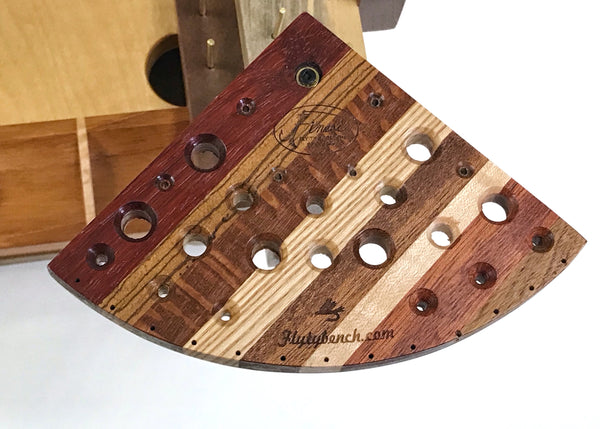The tool swivel plate has holes for many different tools. The beveled holes make it easier to place the tool in the hole. The thirteen holes on the curved edge are for hanging newly tied flies.